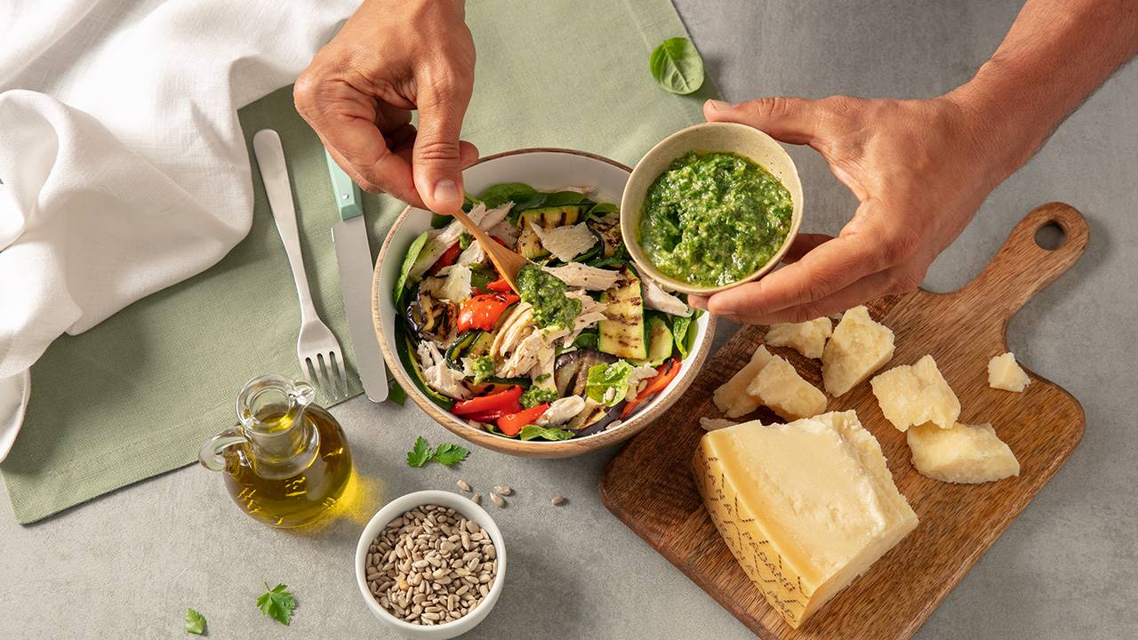 Salat mit Brathuhnstücken, gegrilltem Gemüse der Saison, grüner Sauce und Splittern von Grana Padano