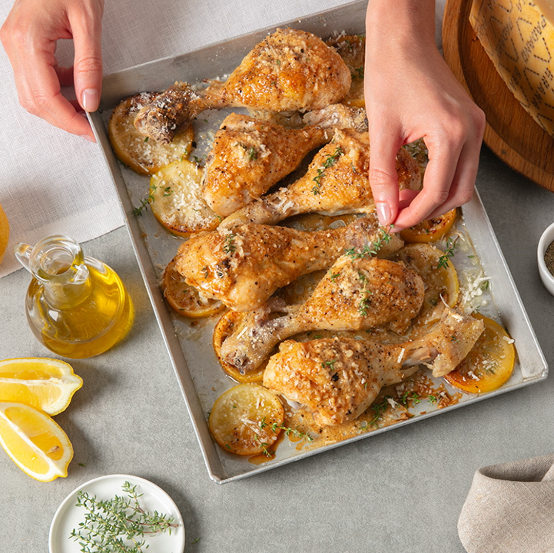 Teglia di cosce di pollo al forno con gratin di Grana Padano, timo e limone