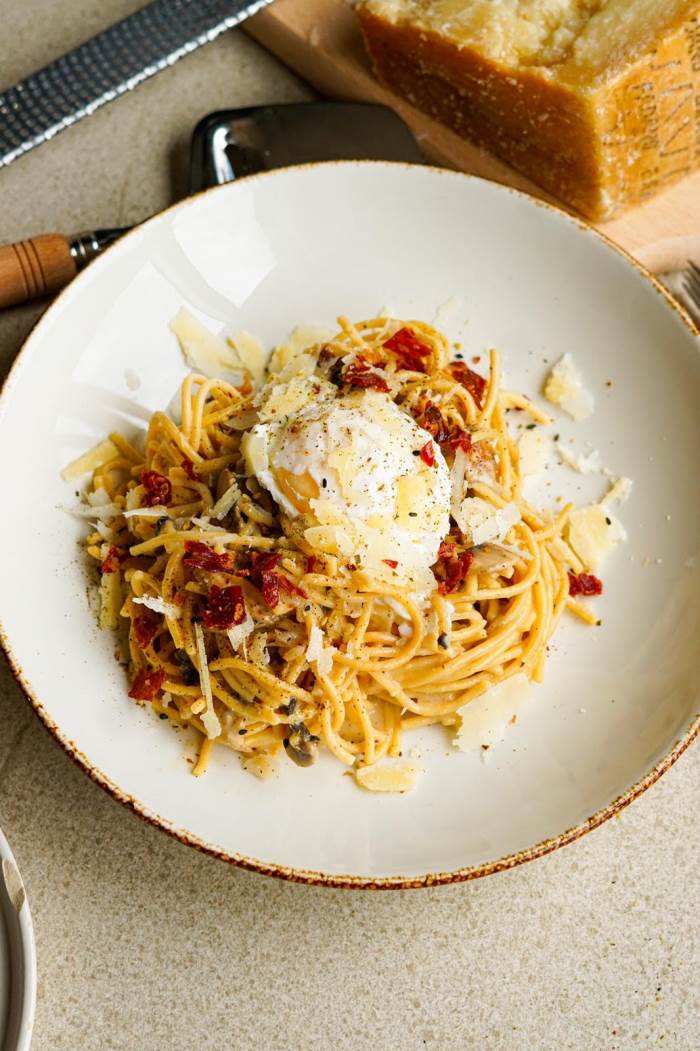 Pasta con salsa de Grana Padano, jamón y huevo pochado