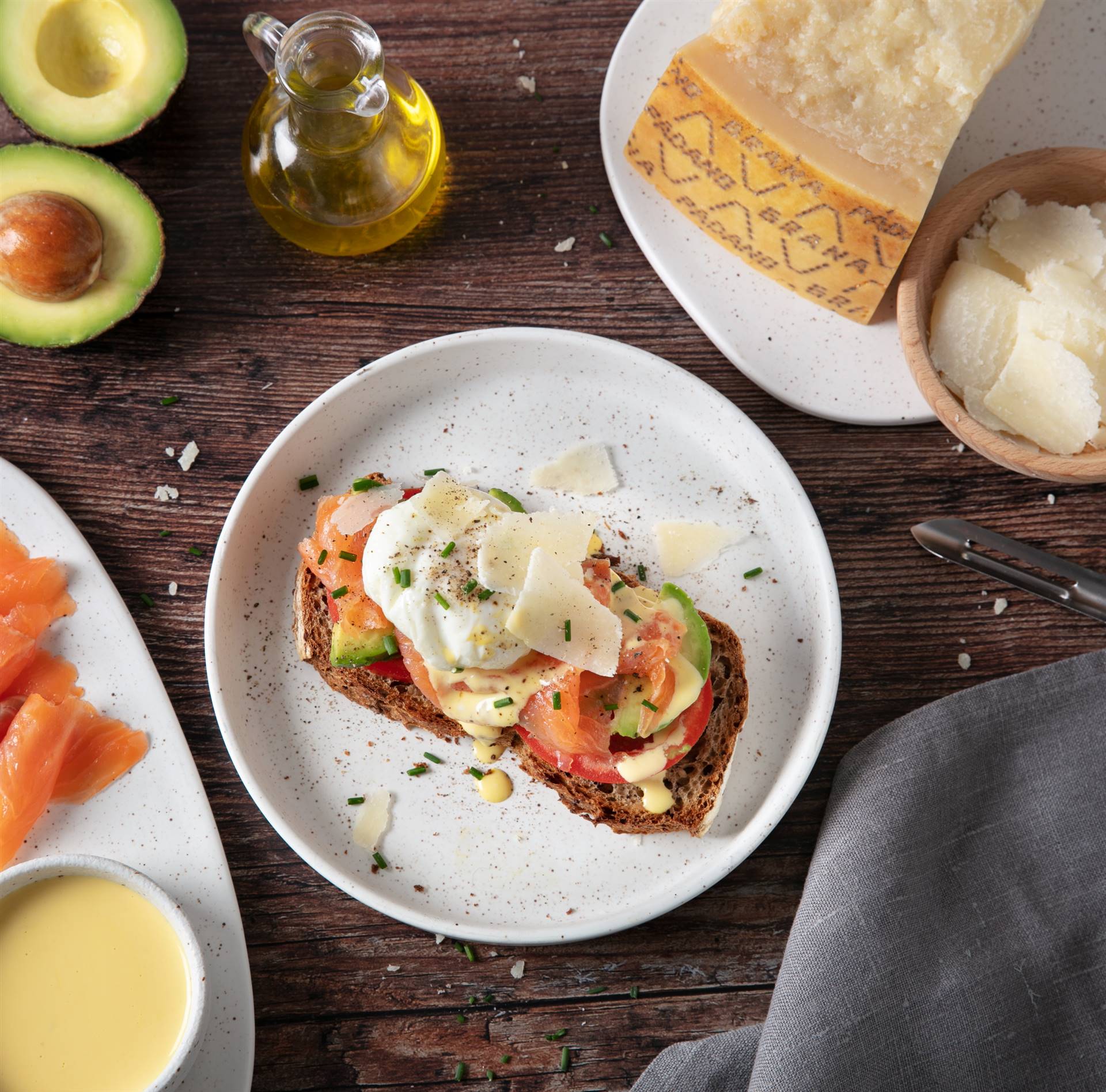 Crostone con uova alla Benedict, salmone, avocado, pomodoro fresco e scaglie di Grana Padano