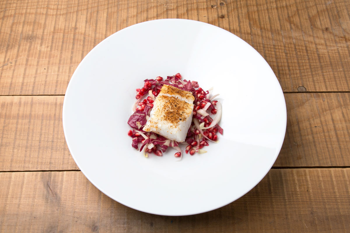 Filetto di baccalà gratinato al panettone e Grana Padano, insalata di indivia e melagrana
