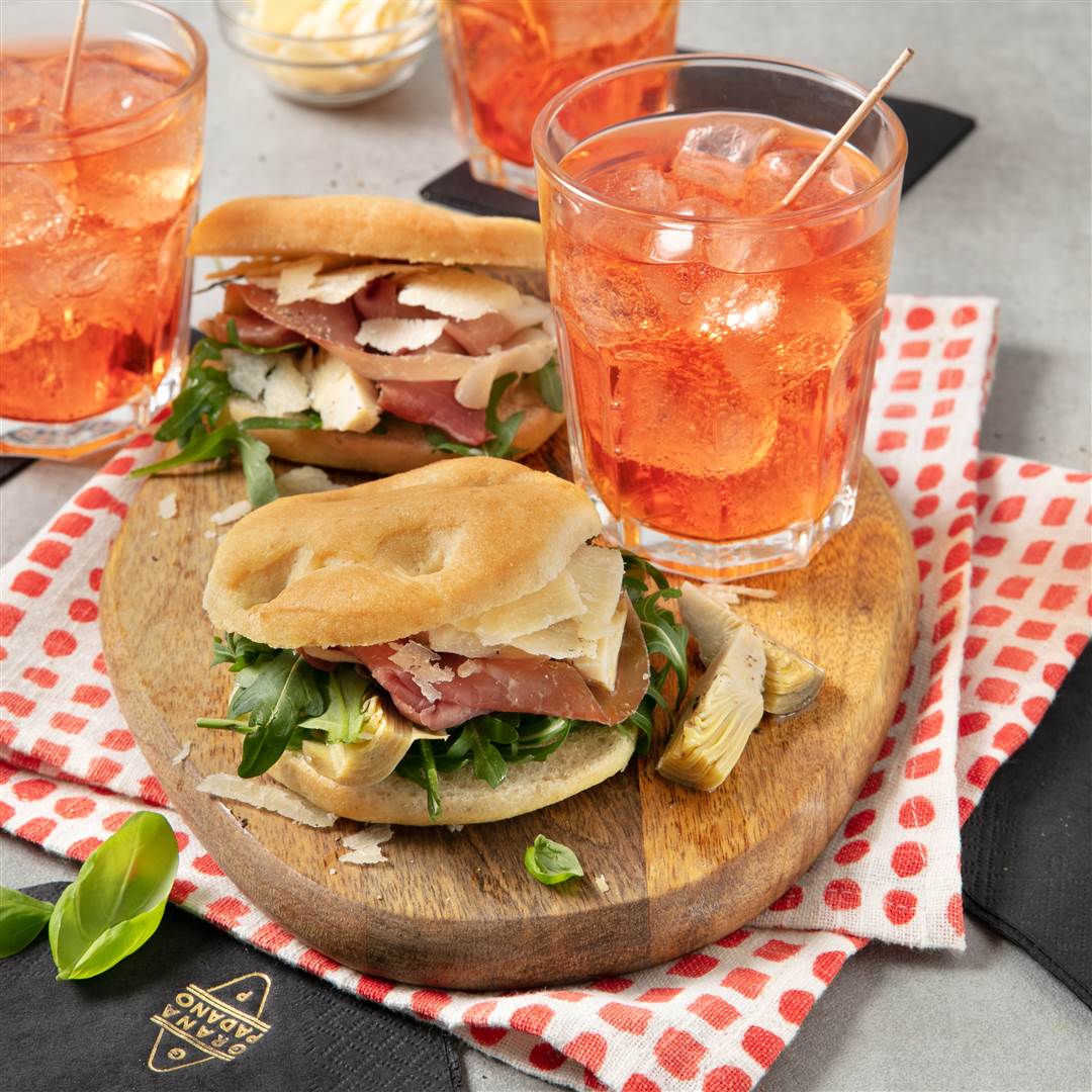 Spritz and mini focaccias with rocket, prosciutto, artichokes in oil and Grana Padano 