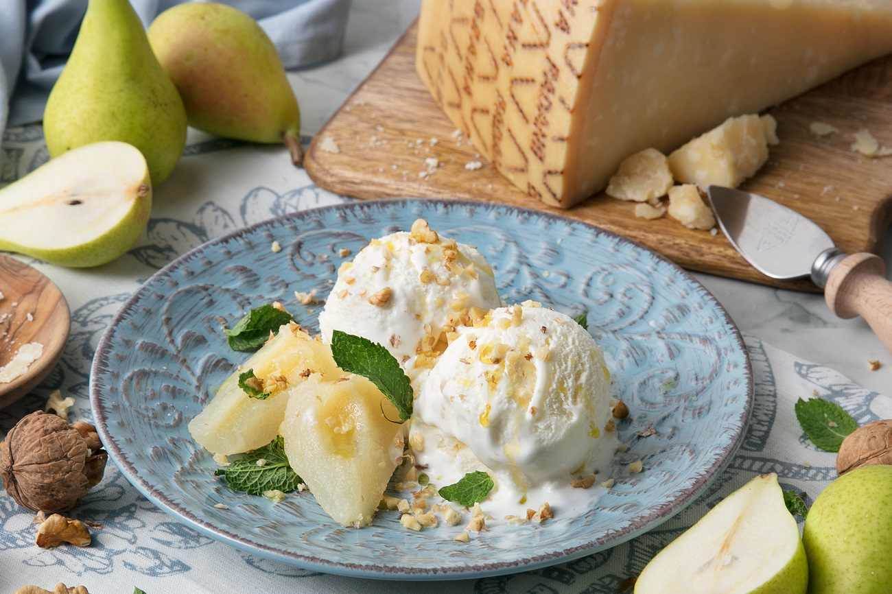 Helado al Grana Padano DOP con peras en almíbar, granillos de nueces y hojas de menta fresca