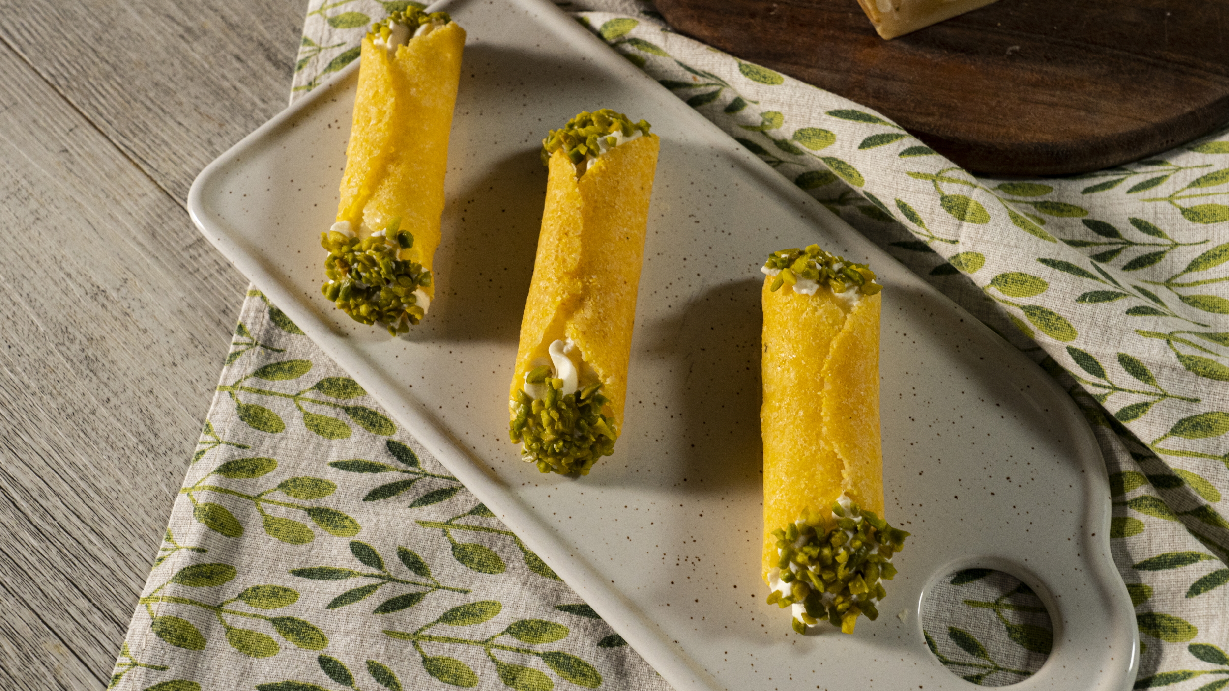 Roulés au Grana Padano, mousse au fromage de chèvre, agrumes et pistaches concassées