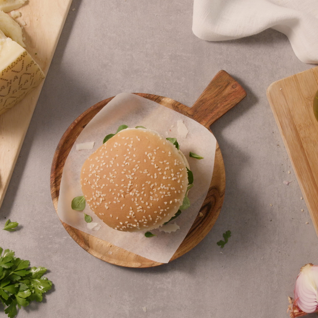 Hamburger aus Rindfleisch mit Grana Padano, karamellisierten Zwiebeln und Pflücksalat