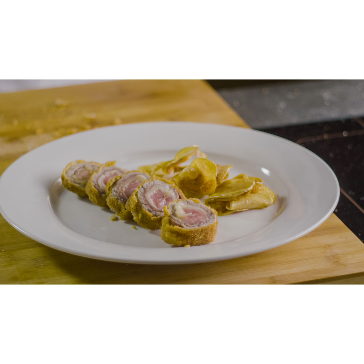 Involtino di vitello con prosciutto crudo, scaglie di Grana Padano e chips di patate