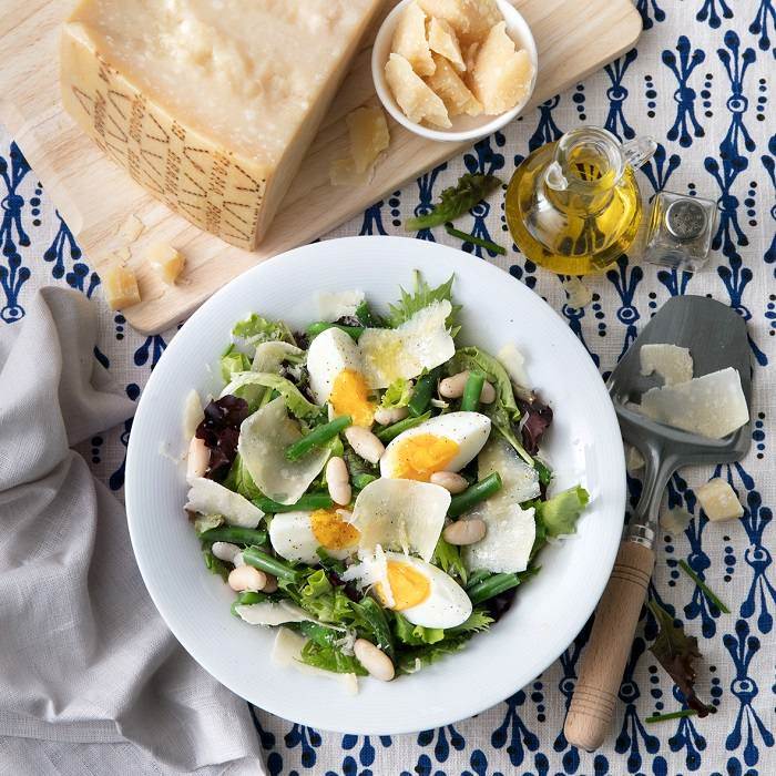 Bunte Salatschüssel mit gemischtem Blattsalat, weißen Bohnen, grünen Bohnen, Eiern, Schnittlauch und Grana Padano