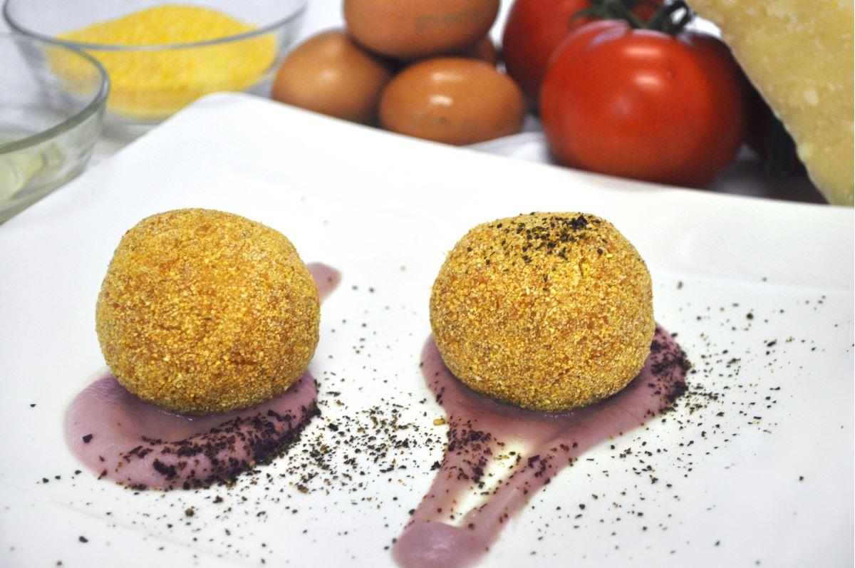 Arancini “doppia croccantezza” con ripieno liquido al Grana Padano su crema di melanzane