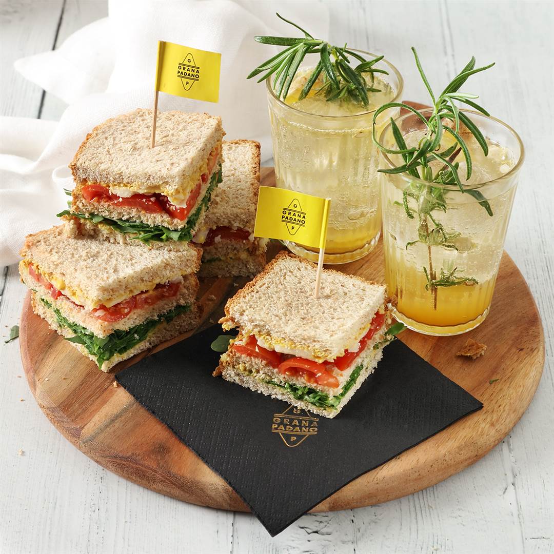Pineapple juice, tonic water, ginger and rosemary mocktail, mini whole wheat sandwiches with tomato, rocket, mustard and shavings of Grana Padano
