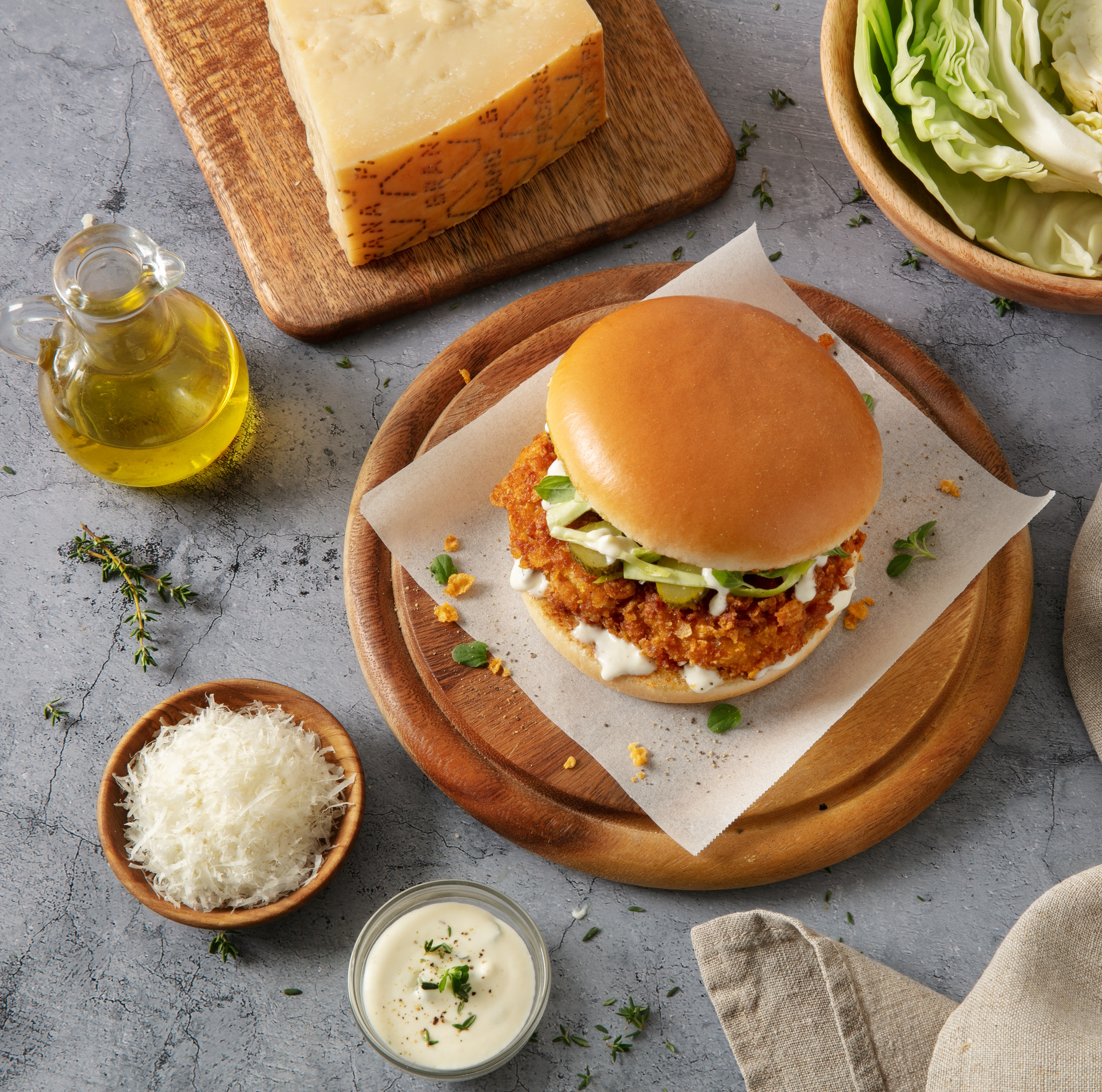 Sandwich mit frittiertem hähnchen, Grana Padano-sauce mit aromatischen Kräutern, Weisskohl und Essiggurken