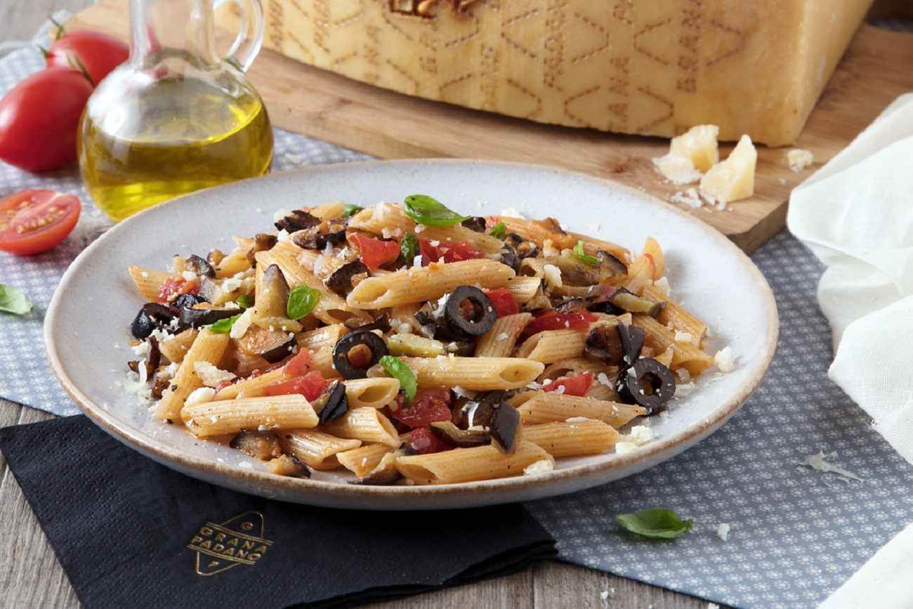Pasta pluma con berenjenas, aceitunas negras, tomate fresco, albahaca y Grana Padano Riserva