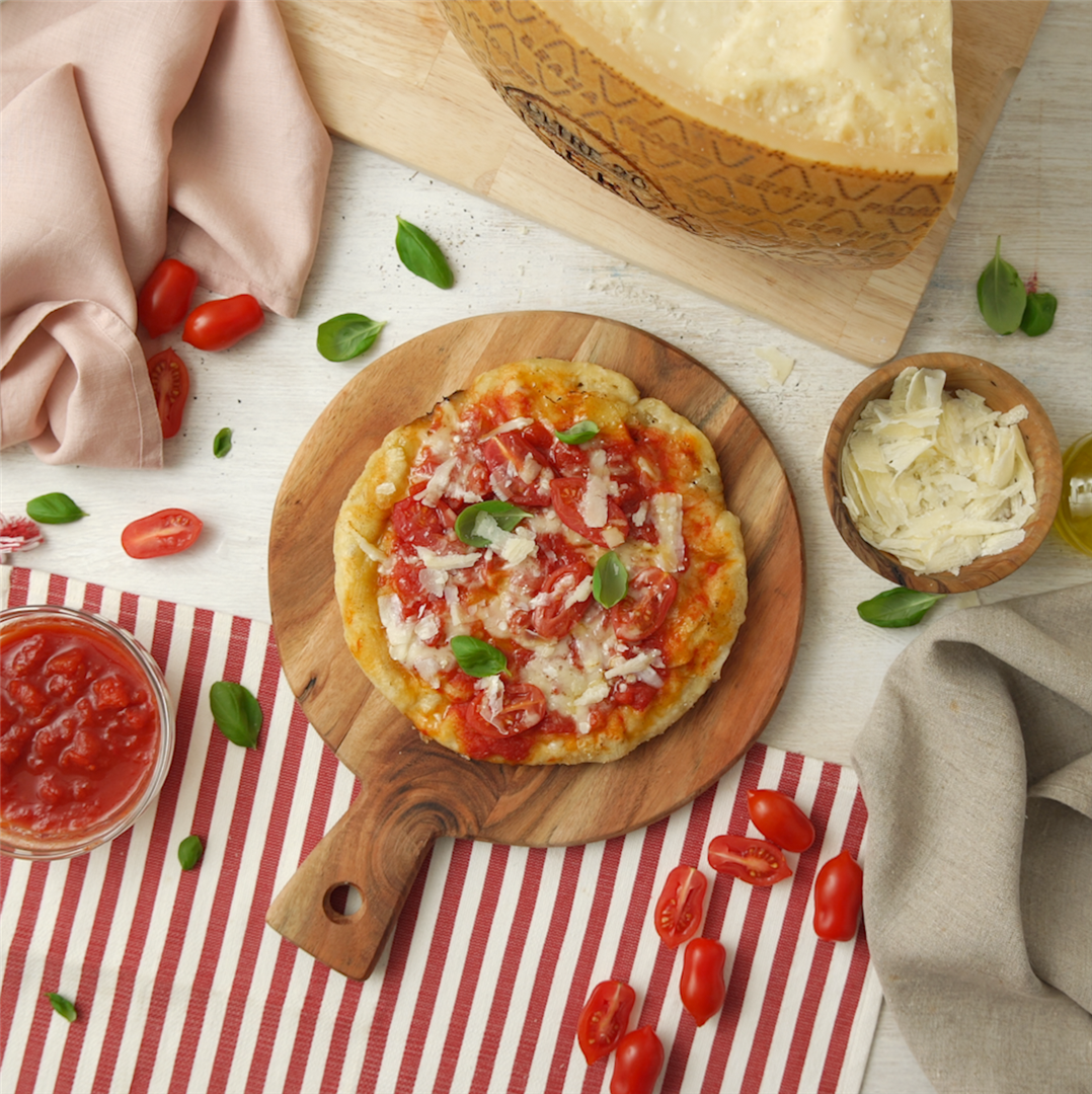 Pizza in der Pfanne mit Tomaten, Basilikum und Grana Padano Riserva ...