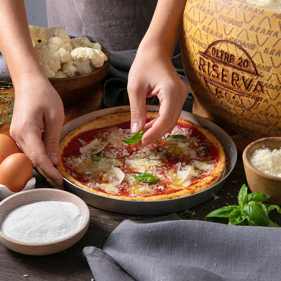 Pizza mit Blumenkohl-Grana Padano Riserva-Boden, belegt mit Tomatensauce, gegrilltem Gemüse und Grana Padano Riserva-Splittern