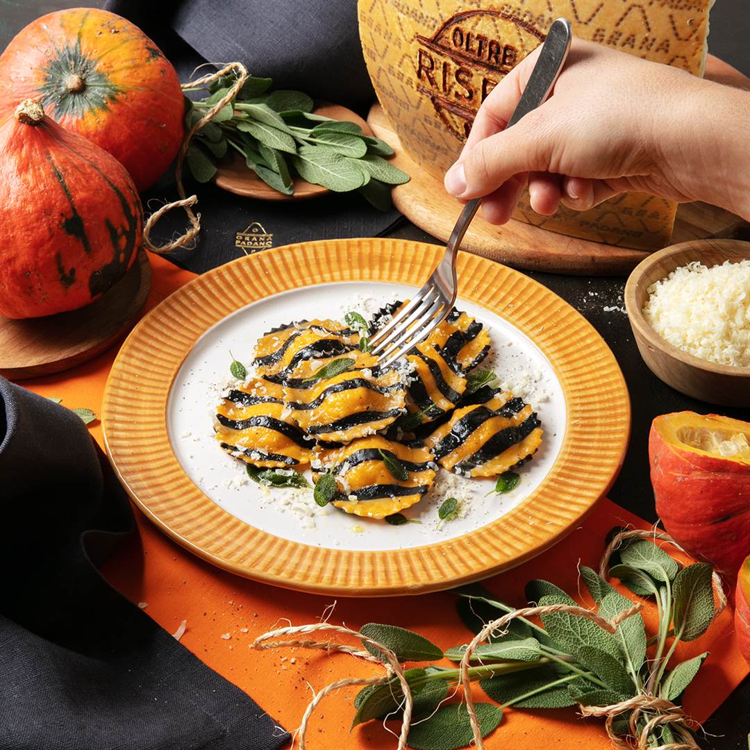Gelb-schwarz gestreifte Ravioli (Tintenfischtinte und Safran) gefüllt mit Grana Padano Riserva 