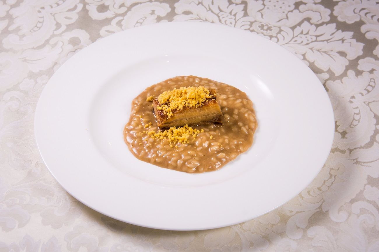 Risotto al fondente di cipolla, pancetta e biscotto salato al Grana Padano