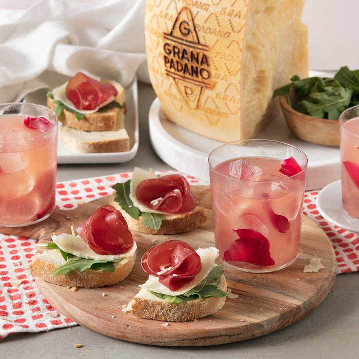 Rose Lemon Spritzer con crostini bresaola, rucola, limone e scaglie di Grana Padano 