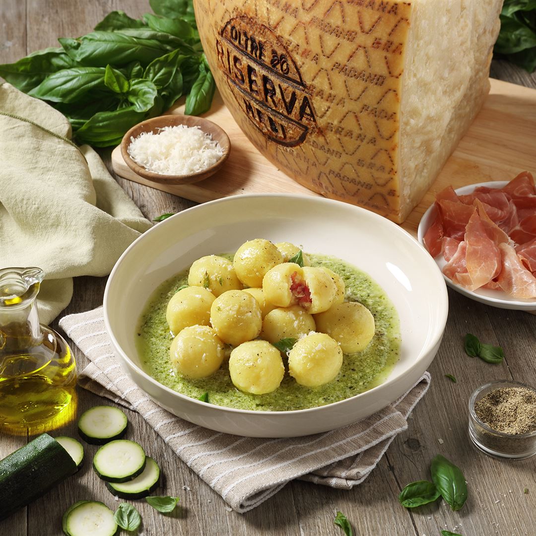 Gnocchi de patatas relleno de Grana Padano Riserva y prosciutto, adornado con courgette y pesto de albahaca