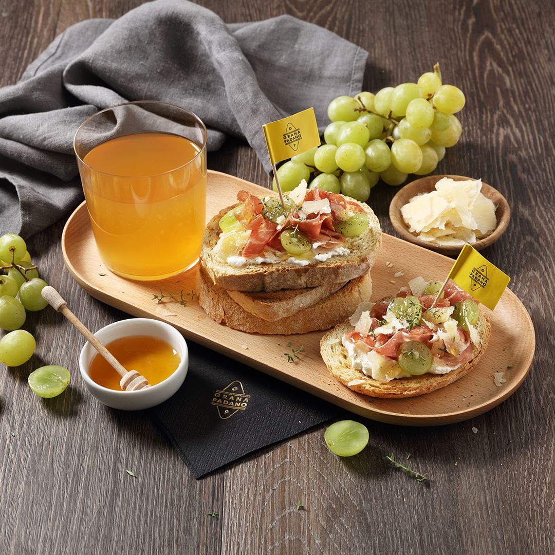 Cidre de pommes, tartines de pain de campagne au raisin blanc, jambon cru, miel et copeaux de Grana Padano