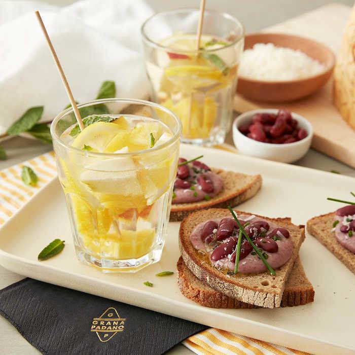 Sangria bianca analcolica e crostini di pane di segale con hummus e Grana Padano