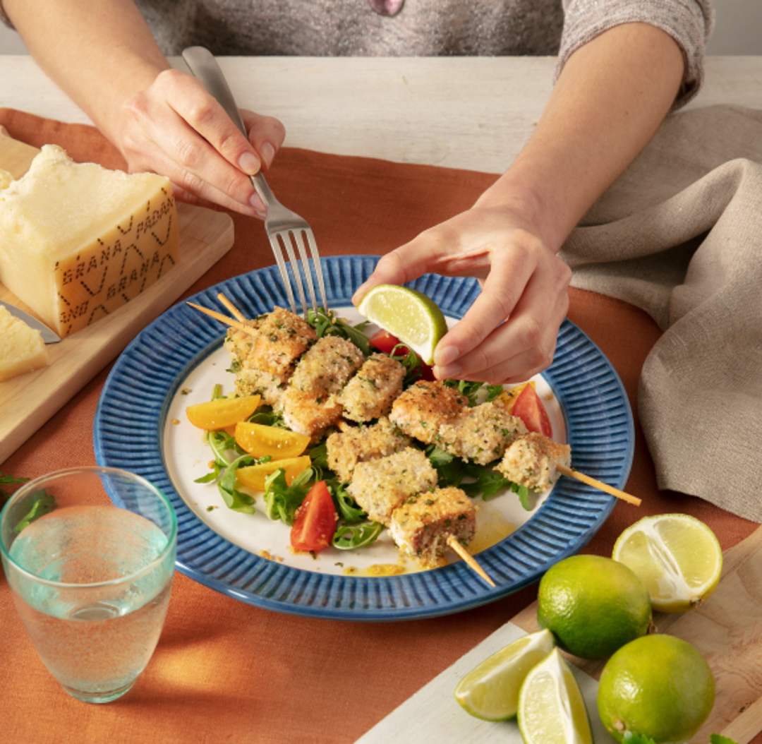 Spiedini di pesce gratinati al forno con Grana Padano, pangrattato, lime e prezzemolo