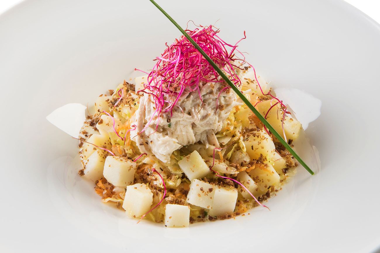 L’insalata di pollo mantecato al Grana Padano con Iceberg, julienne di carote, cubetti di patate, germogli e briciole di pane nero
