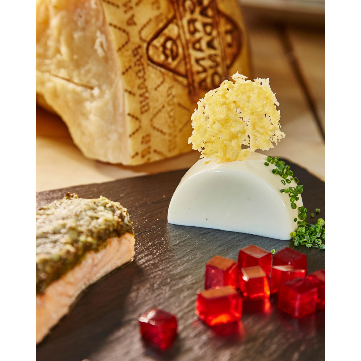 Grana Padano Panna Cotta mit Chips, Lachs, Olivenkruste und Rosé Gelee