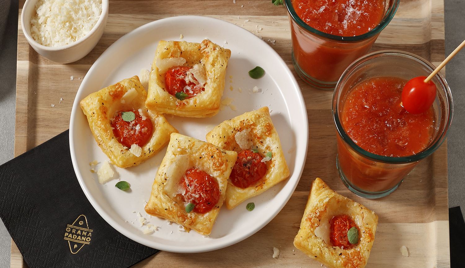 Alkoholfreier Tomatencocktail und Snacks aus Blätterteig und Tomaten mit Oregano und Grana Padano Riserva