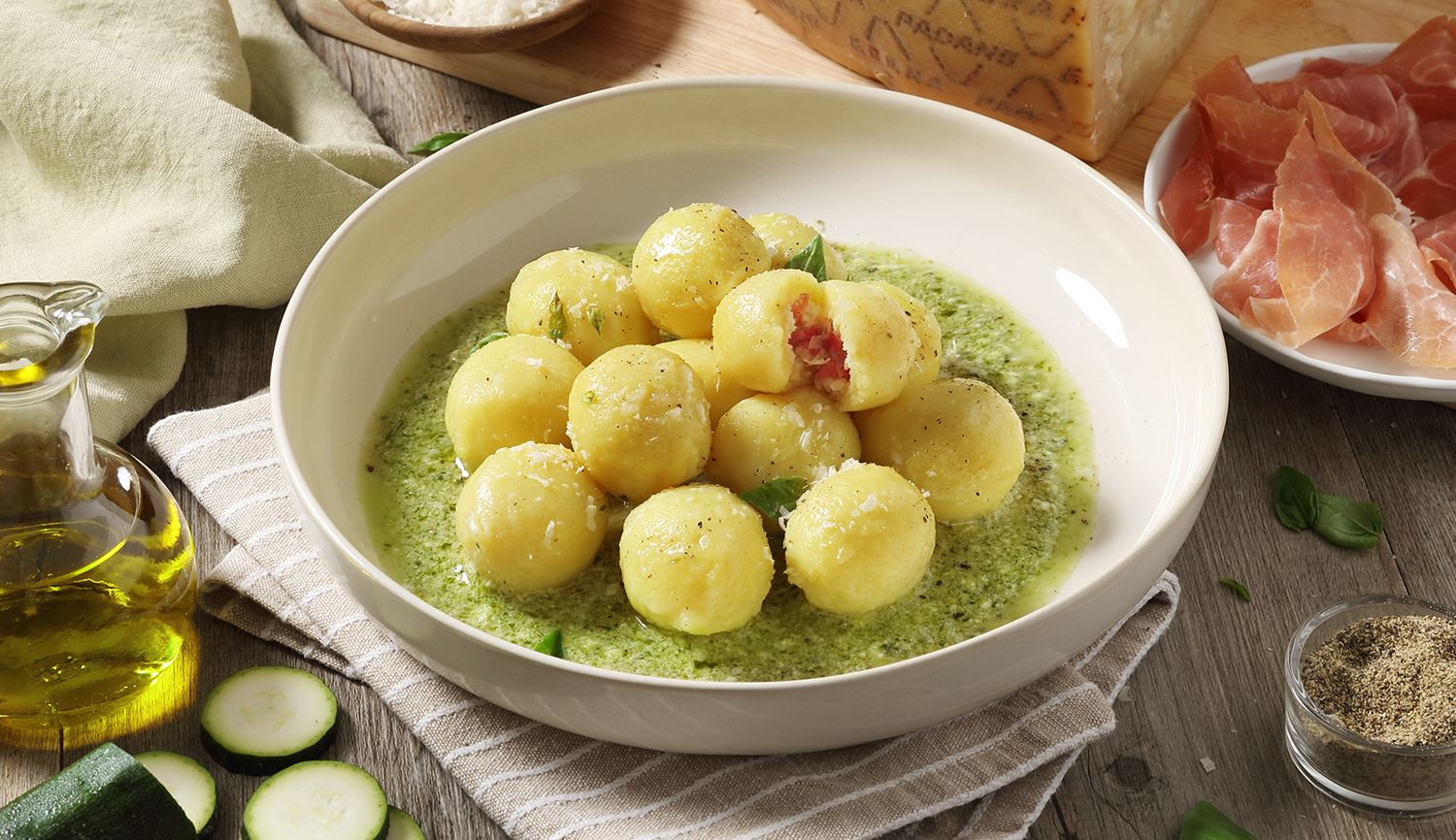 Gnocchi de patatas relleno de Grana Padano Riserva y prosciutto, adornado con courgette y pesto de albahaca