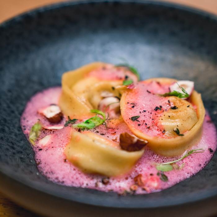 Selbstgemachte Tortelloni mit Grana Padano-Pilz Füllung auf Rote Bete Schaum und brauner Butter
